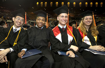 Four graduated students smiling
